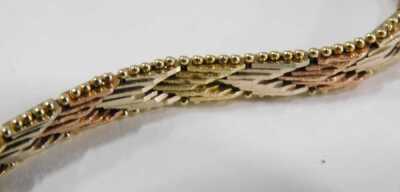 A three colour gold bracelet, in a textured herringbone design, on a snap clasp, stamped 14ct, 15.0g. - 2
