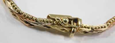 A three colour gold bracelet, in a textured herringbone design, on a snap clasp, stamped 14ct, 15.0g. - 3