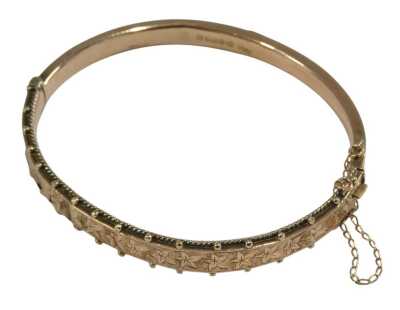 A 9ct rose gold bangle, with engraved foliate decoration, on a snap clasp, with safety chain as fitted, 7.8g.