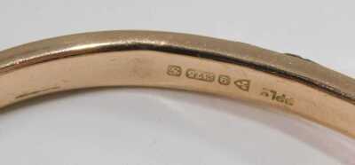 A 9ct rose gold bangle, with engraved foliate decoration, on a snap clasp, with safety chain as fitted, 7.8g. - 2