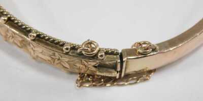A 9ct rose gold bangle, with engraved foliate decoration, on a snap clasp, with safety chain as fitted, 7.8g. - 3