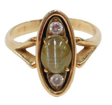 A 20thC cat's eye chrysoberyl and diamond three stone dress ring, in the Art Deco style, set with central greenish yellow cabochon cut chrysoberyl, 7mm x 5.5mm x 2mm, approx 0.78ct, claw set, flanked by two round brilliant cut diamonds, each approx 2.5mm 