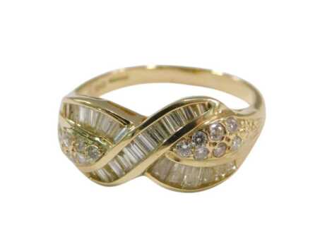 An 18ct gold and diamond ring, in a crossover style, set with baguette diamonds and raised brilliant cut diamonds, size T½, 5.9g.