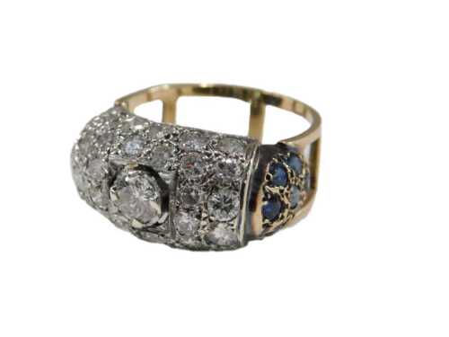 An Art Deco style 18ct gold diamond and sapphire ring, central claw set with a diamond, in a pave surround of further diamonds, with sapphire set shoulders, on an openwork shank, size Q½, 6.8g.