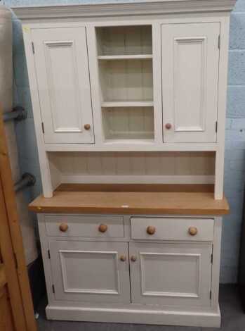 A painted pine and oak dresser, the top with a moulded cornice above three central shelves, flanked by two cupboard doors, the base with two drawers above two cupboards, on a plinth, 110cm high, 130cm wide, 50cm deep.