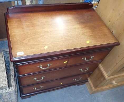 A chest of drawers, with raised back, above three long drawers.