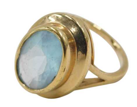 An aquamarine dress ring, the ring set with oval faceted aquamarine, in a raised rub over circular setting, on V splayed shoulders, yellow metal, unmarked, ring size R, 6.4g all in.