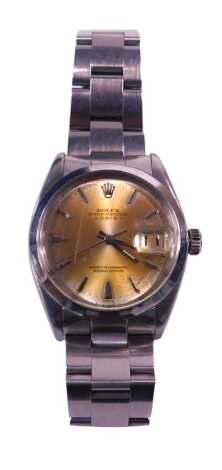 A Rolex Oyster Perpetual date automatic wristwatch, with gold coloured dial, stamped superlative chronometer, in a steel case with Rolex strap, some associated paperwork, lacking box, the dial 3cm diameter.