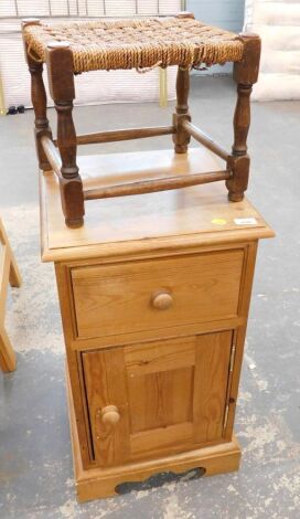 A pine bedside cabinet, the moulded top above a frieze drawer, with a panelled cupboard, on bracket feet, 70cm high, together with an oak framed stool, with a woven seat.