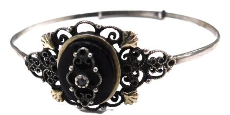 An early 20thC black onyx marcasite and filigree bangle, in white metal.