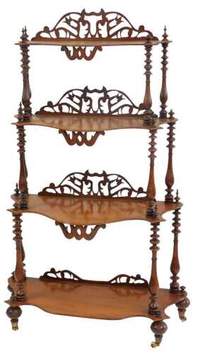 A Victorian mahogany four-tier waterfall whatnot, each shaped shelf with a raised pierced back, united by turned columns, on ceramic castors, 140cm high, 69cm wide, 32cm deep.