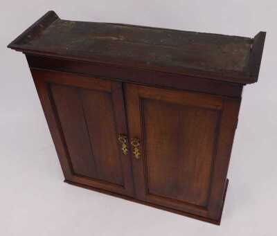 An 18thC oak cabinet, the top with a moulded edge, above two panelled doors enclosing three shelves, on a stepped base, 95cm high, 97cm wide, 31cm deep. - 2