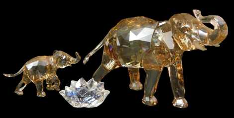 A Swarovski crystal 2013 Edition Cinta elephant, 11cm high, with glass name plaque, together with calf, 5cm high, both with certificate of authenticity, boxed. Upon initial inspection no apparent damage.