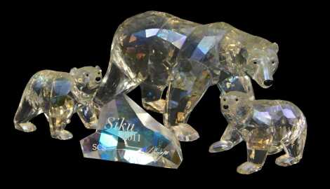 A Swarovski crystal 2011 edition Siku polar bear, with name plaque, 8.5cm high, together with two cubs, 6cm high, each with a certificate of authenticity, boxed. Upon initial inspection no apparent damage.