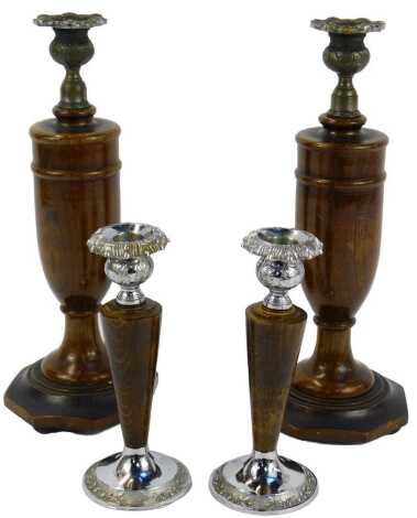 A pair of 20thC turned oak candlesticks, with metal mounts, on an octagonal base with three compressed bun feet, 31cm high, a further pair of candlesticks, 18cm high.