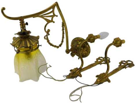 An early 20thC brass wall light by Darwin's, with a frosted yellow shade decorated with etched flowers, converted to electricity, 34cm high, together with a pair of brass single wall lights, the bracket decorated with a bow, etc., 29cm high. (3)