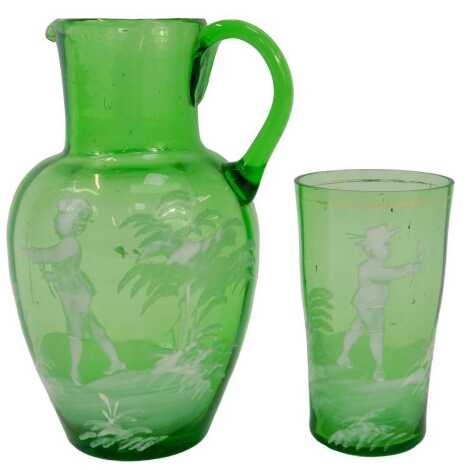 A 19thC Mary Gregory style green glass jug, decorated in white enamels depicting a young boy amongst foliage, 13.5cm high, together with a similar beaker, 8.5cm high.