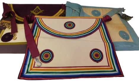 A Masonic regalia apron and sash, with a multicoloured rosette.