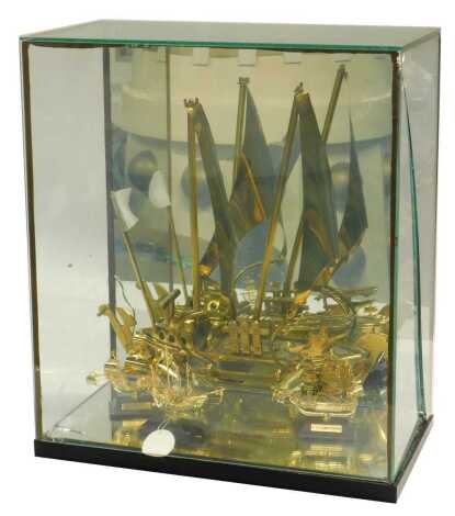 A 20thC brass model of a sailing boat, 34cm high, contained in a glass case, together with three further miniature brass ships comprising the Santa Maria, on a wooden stand, 9cm high, USS Constitution, and another, the case 44cm high. (AF)