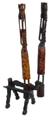 A pair of hardwood tribal figures, modelled as women on circular bases, 152cm high, together with an ebonised camel stool, lacking seat, 40cm high.