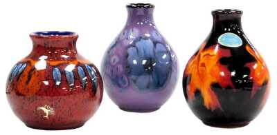 A Poole pottery Jasmine pattern vase, 13.5cm high, Forest Flame pattern vase, 13cm high, and a further vase in the Volcano pattern, 10.5cm high. (3)