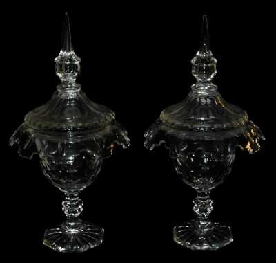 A pair of 19thC cut glass sweetmeat jars and covers, with a faceted lid with pointed finial, the bowl with a shaped everted rim, raised on a faceted hourglass stem, above an octagonal foot, 34cm high.