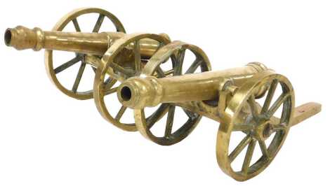 A pair of brass table cannons, 52cm wide.