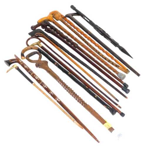 A group of African carved walking sticks, with figural terminals, further sticks, and a riding crop.