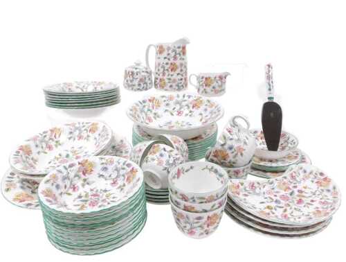 A Minton porcelain Haddon Hall pattern part dinner and tea service, comprising an oval meat platter, a pair of serving dishes, four crescent shaped dishes, dessert and soup plates, fruit bowls, cream jug, sucrier, teacups and saucers.