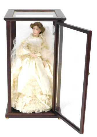 A Franklin Heirloom doll, in an ivory wedding dress, with lace veil, in a wooden cabinet, cabinet 66cm high.