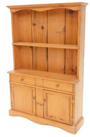 A miniature replica pine dresser, the back with a single shelf, the base with two short drawers and two panelled doors, on shaped plinth, 55cm high, 36cm wide.