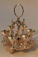 A silver plated egg cruet with six cups and spoons.