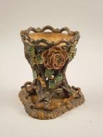 A Victorian stoneware flower encrusted jardiniere and triform stand