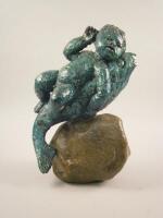 An unusual 20thC green painted plaster sculpture of a boy riding a fish