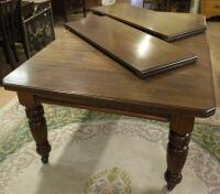 An Edwardian walnut extending dining table