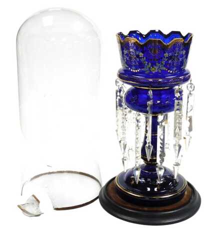 A late 19thC continental cobalt blue glass lustre, with gilt and painted floral swag and leaf decoration, with clear prismatic and brilliant cut drops, on an ebonised base with glass dome, lustre 37cm high, dome AF.