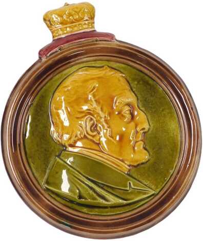 An early 19thC pottery memorial plaque to the Duke of Wellington, showing a bust portrait, within a circular frame, and crown surmount, 25cm wide.