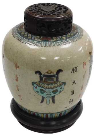 A 19thC Qing period Chinese crackle glaze jar, with polychrome decoration of poems and precious objects, including a censer, painted four character mark to base, with a carved hardwood stand and cover, 32cm high.