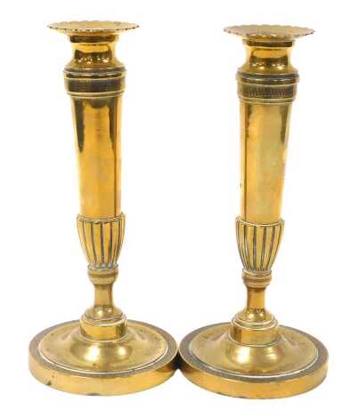 A pair of Regency loaded brass candlesticks, of partially fluted form, raised on an outswept base, with bands of acanthus leaves, 26cm high.