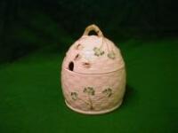 A Belleek honey pot, modelled as a basketweave hive and decorated in relief