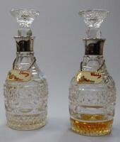 A pair of cut glass mallet shaped decanters and stoppers