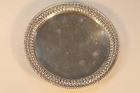 An Indian white metal salver with beaded rim