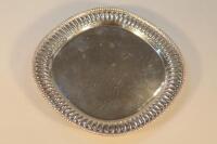 An Indian white metal salver with beaded rim