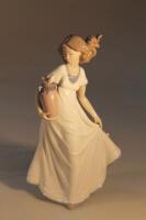 A Lladro figure of a young woman holding a vase