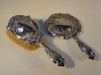 An Edward VII silver backed hand mirror and matching hairbrush