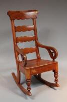 A 19thC stained beech rocking chair with scrolled arms.