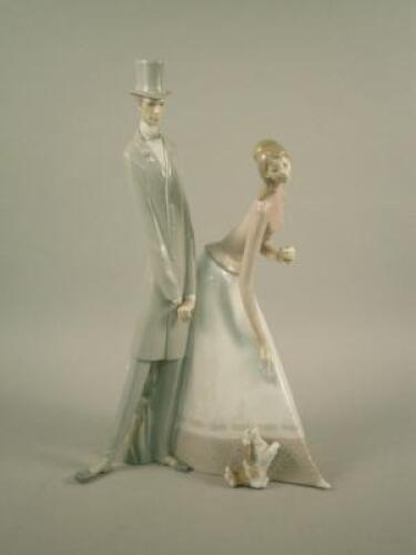 A Lladro figure of a lady and gentleman with dog
