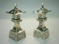 Two Chinese white metal pagoda shaped pepper pots