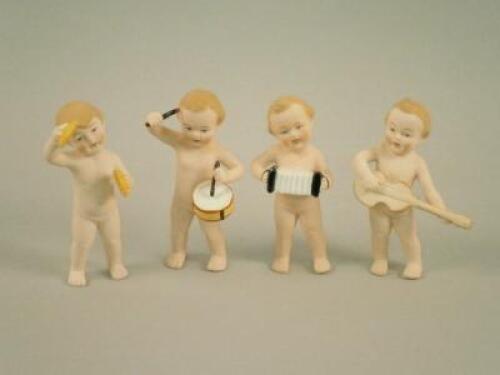 A set of four modern Bisque figures of children playing musical instruments.