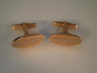 A pair of oval bicolour metal cufflinks stamped 750 and 350